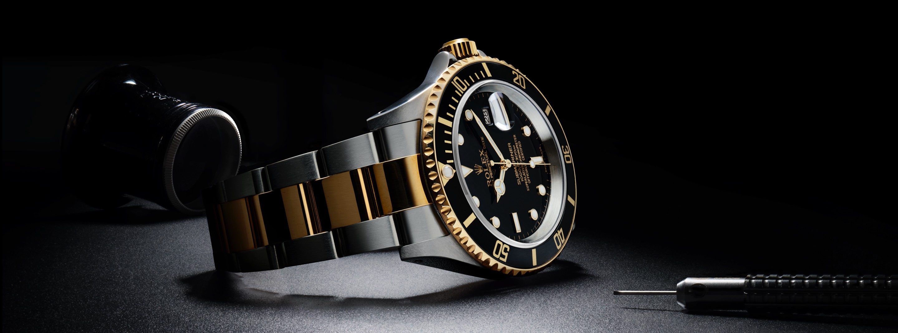 Rolex black and gold watch with link strap
