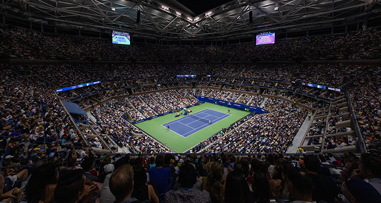 Full stadium watching tennis match at night