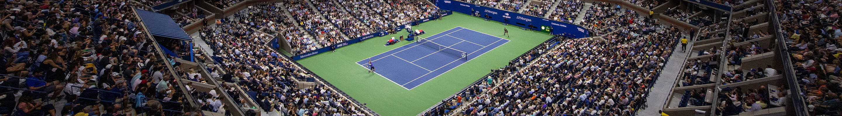 Full stadium watching tennis match at night