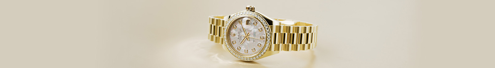 Ladies gold Rolex Datejust watch with link bracelet and diamond detail around dial