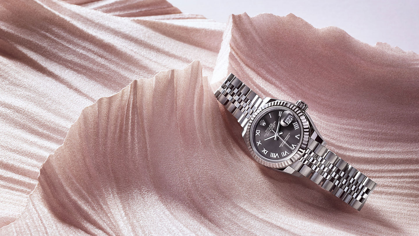 Silver Rolex Lady Datejust watch with black dial on pink setting