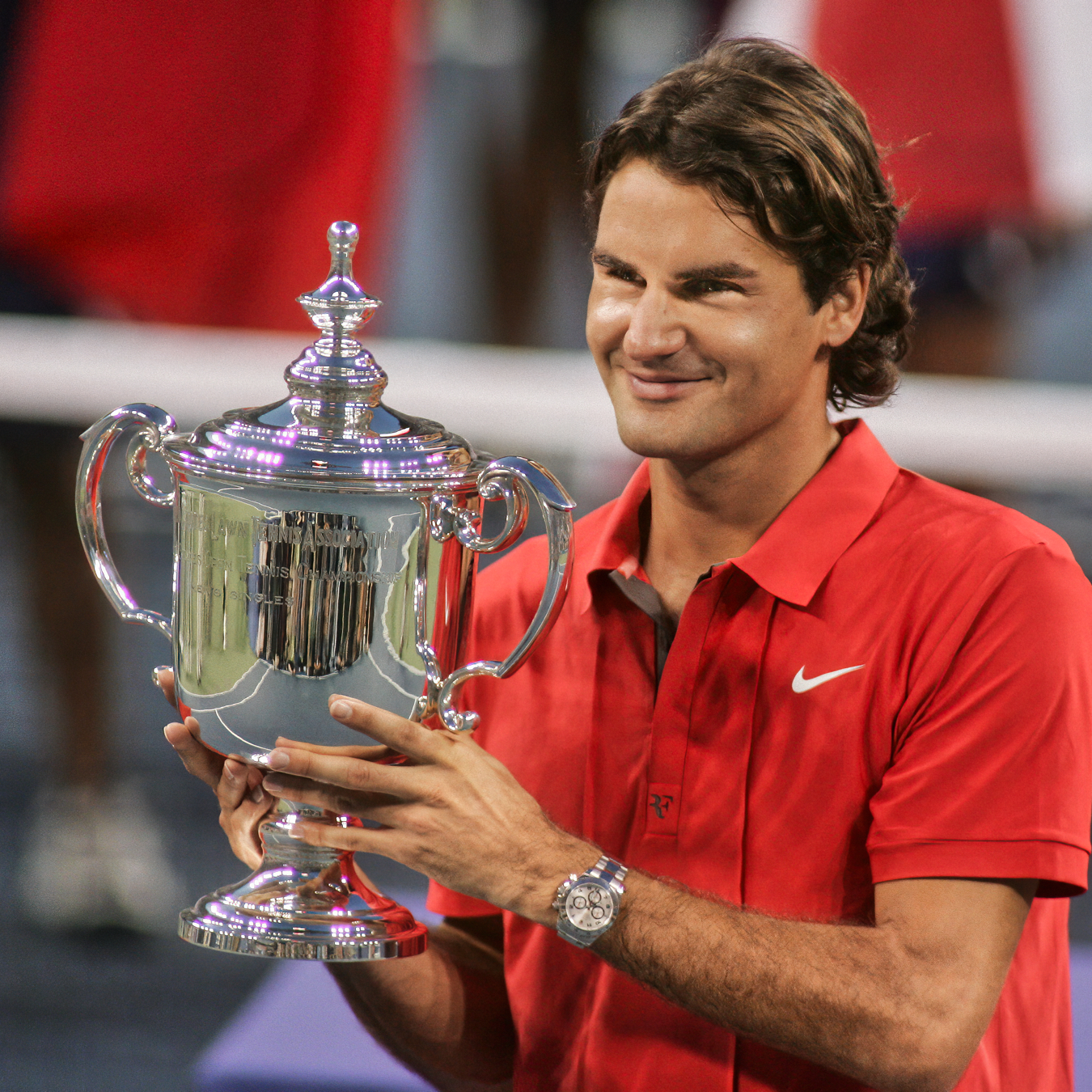 Roger Federer holding Rolex US Open trophy wearing silver Rolex watch