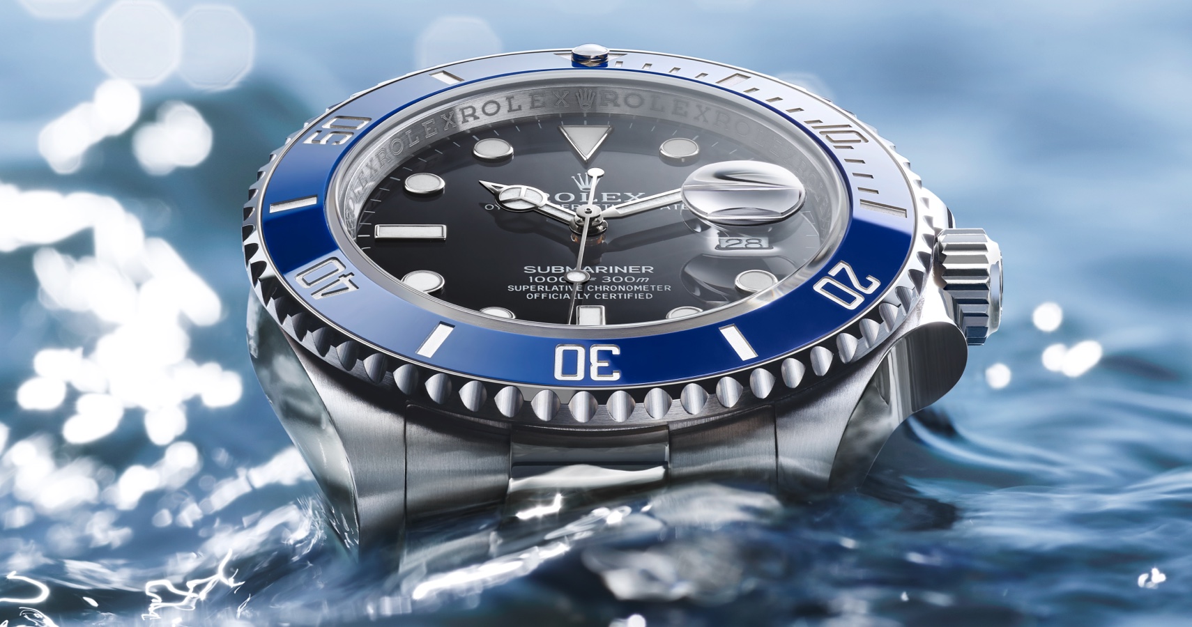 Silver Rolex Oyster Perpetual with black dial and navy detail in water
