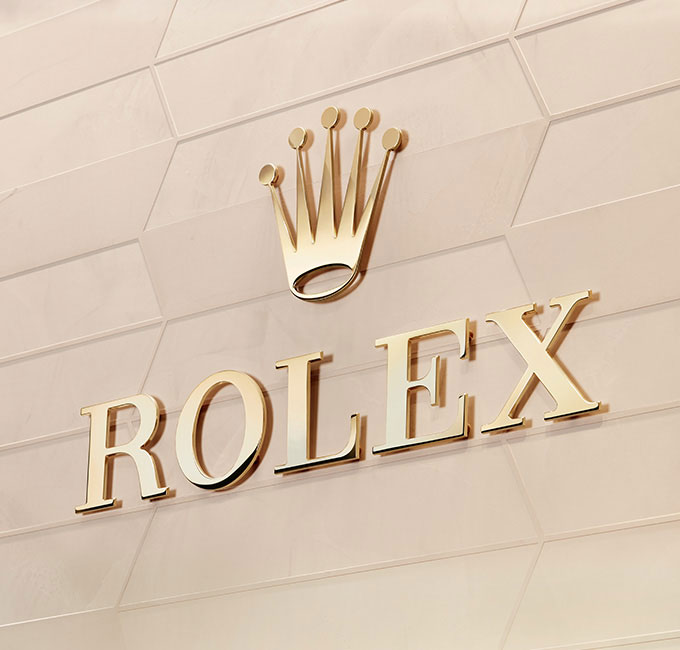 Shiny gold Rolex logo on gold wall