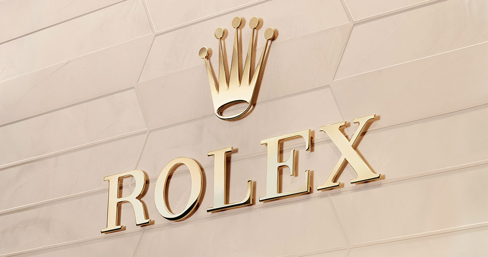 Shiny gold Rolex logo on gold wall